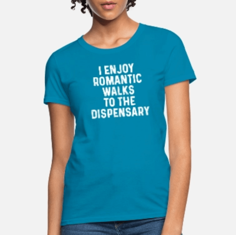 Person wearing a bright blue t-shirt with white text reading I Enjoy Romantic Walks To The Dispensary.